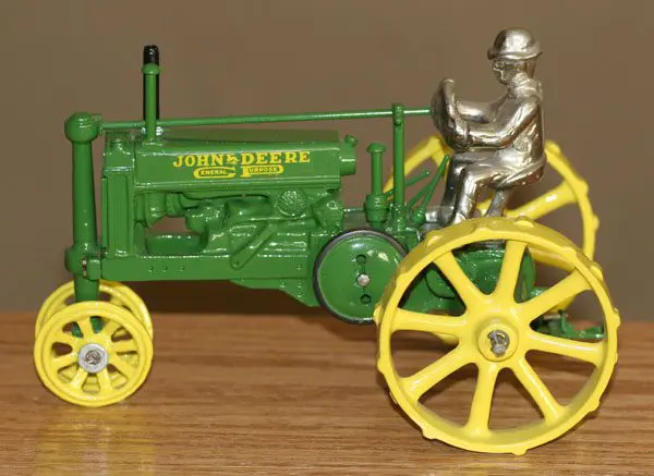 Vintage John Deere toy tractor with driver figurine.