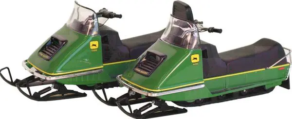 Green vintage snowmobile with sleek design and windshield.