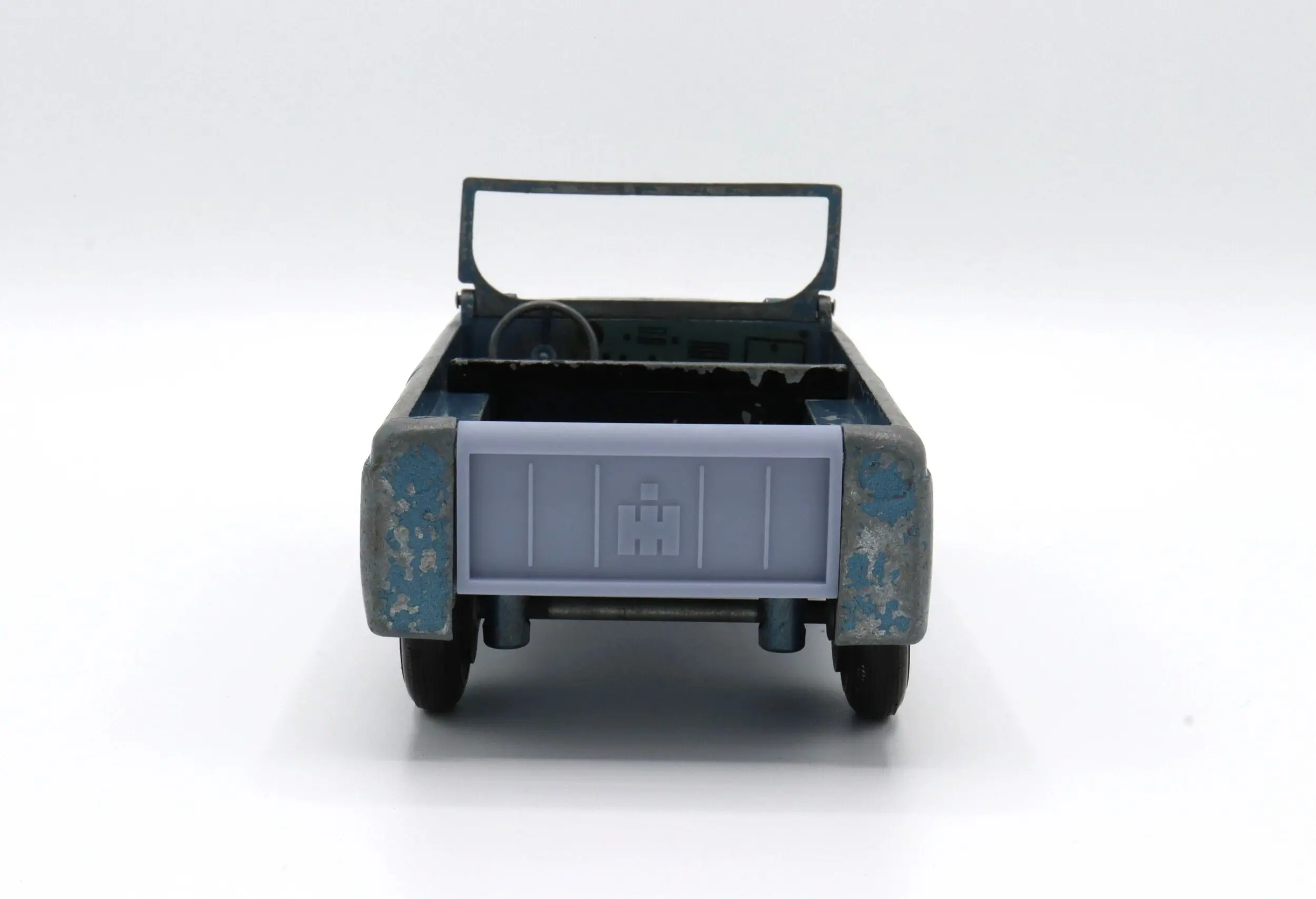 Rear view of a blue pickup truck model with an open cargo bed.
