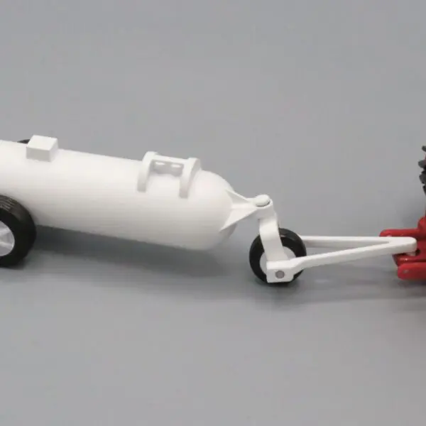 A model of a white tank trailer attached to a red tractor.