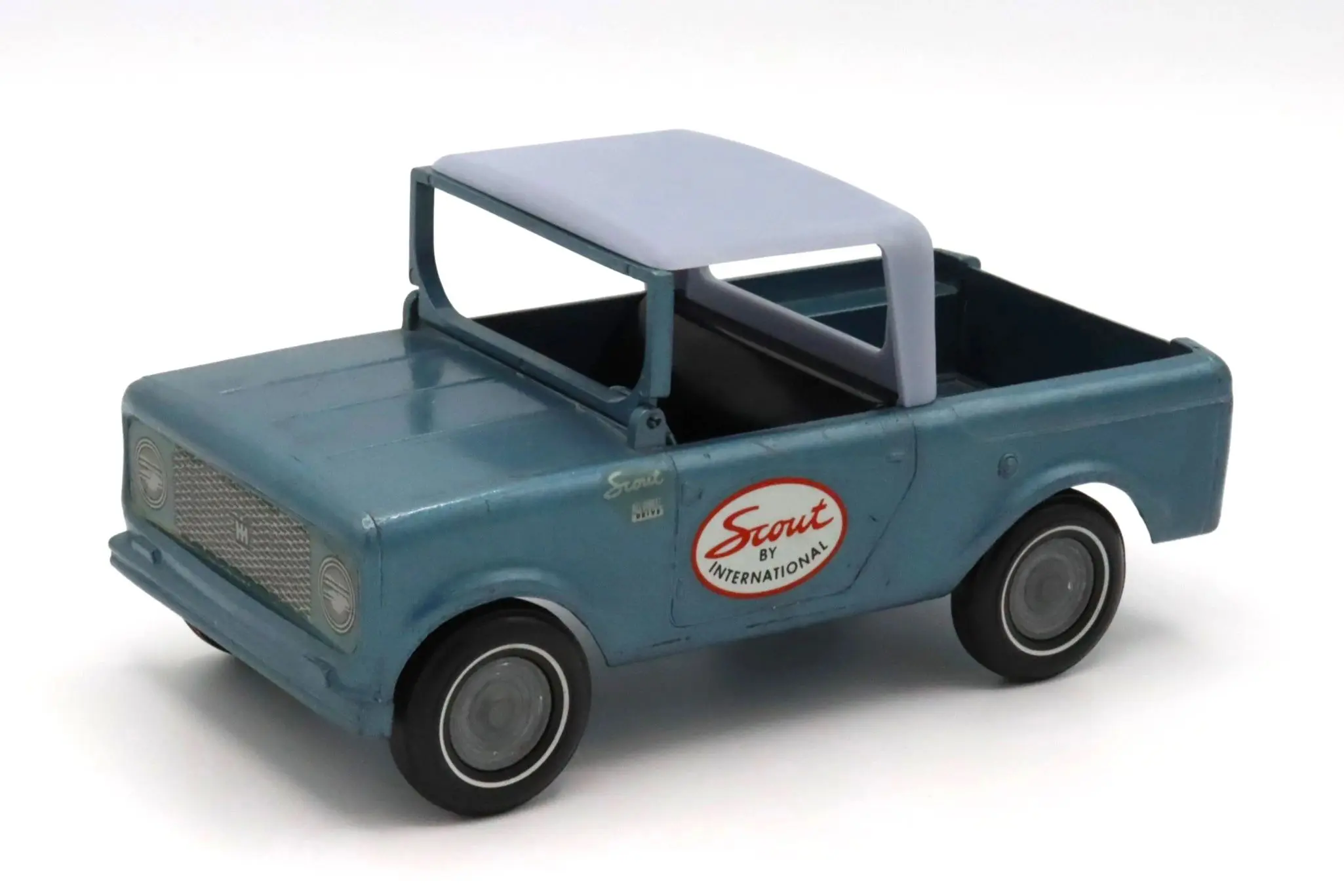 A vintage blue toy pickup truck with a simple design.