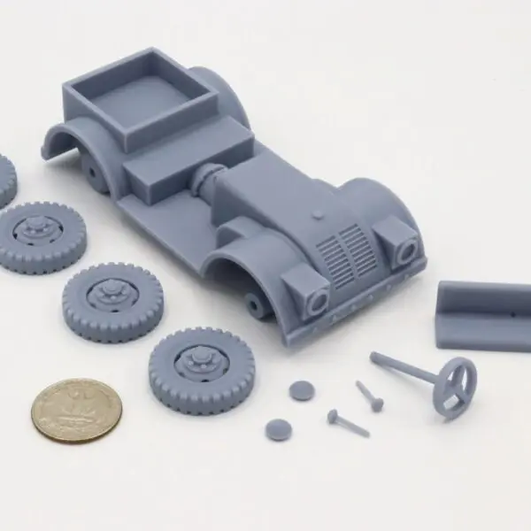 Unassembled gray toy car parts with wheels and screws on a white background.
