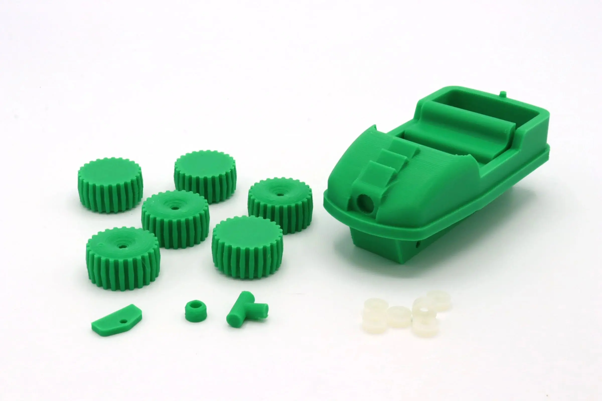 Green toy boat with detachable parts and wheels on a white background.