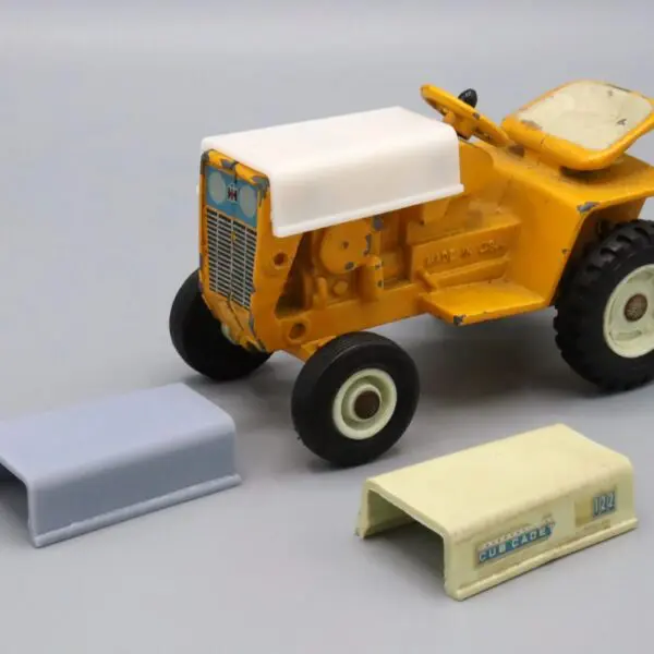 Yellow toy tractor with accessories on a white background.