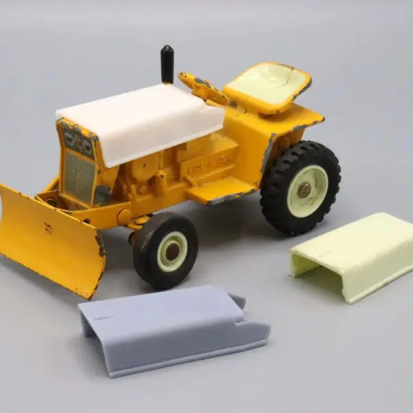 Yellow toy bulldozer with removable parts on a white background.