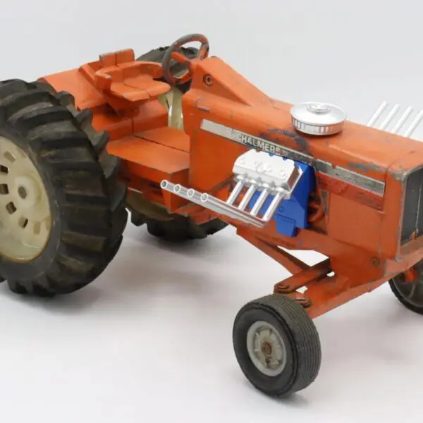 A miniature orange tractor model with detailed features.