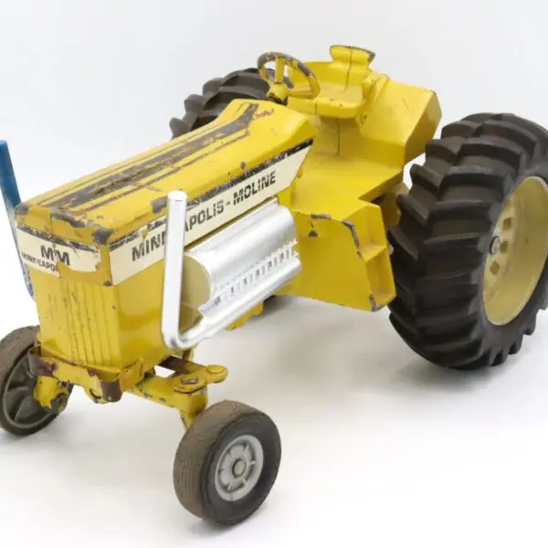 Yellow vintage tractor toy with large rear wheels.