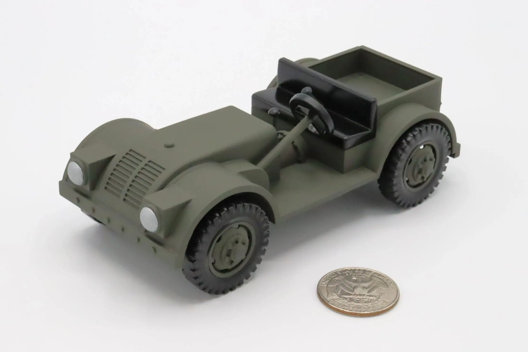 A small green toy military jeep next to a coin for scale.
