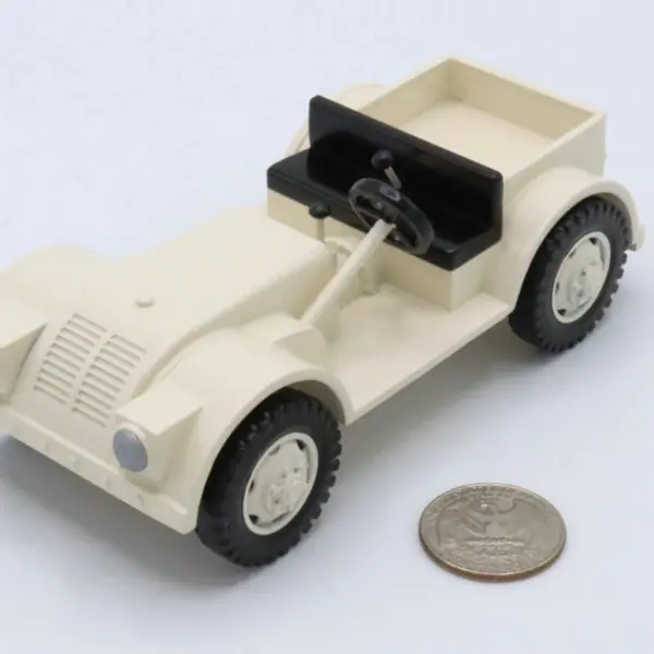 Small beige toy car beside a coin for scale.