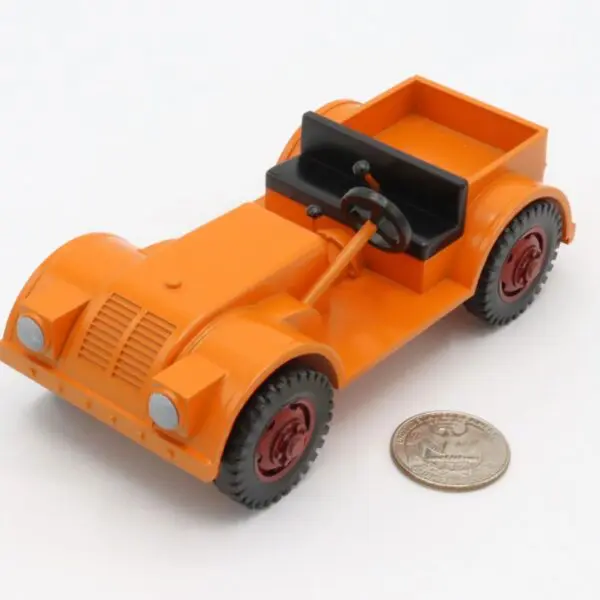 A small orange toy car next to a coin for scale.