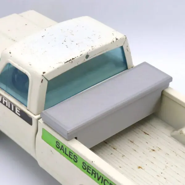 Close-up of a miniature pickup truck bed with a gray bench seat.