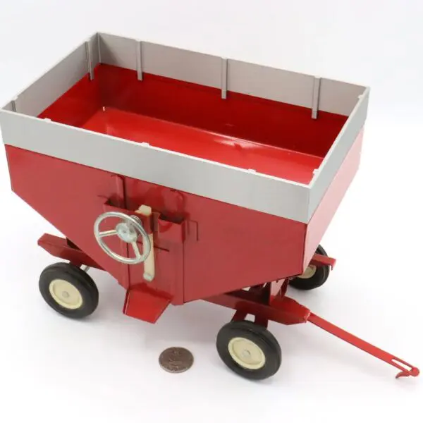 A red toy wagon with a white handle and four black wheels.