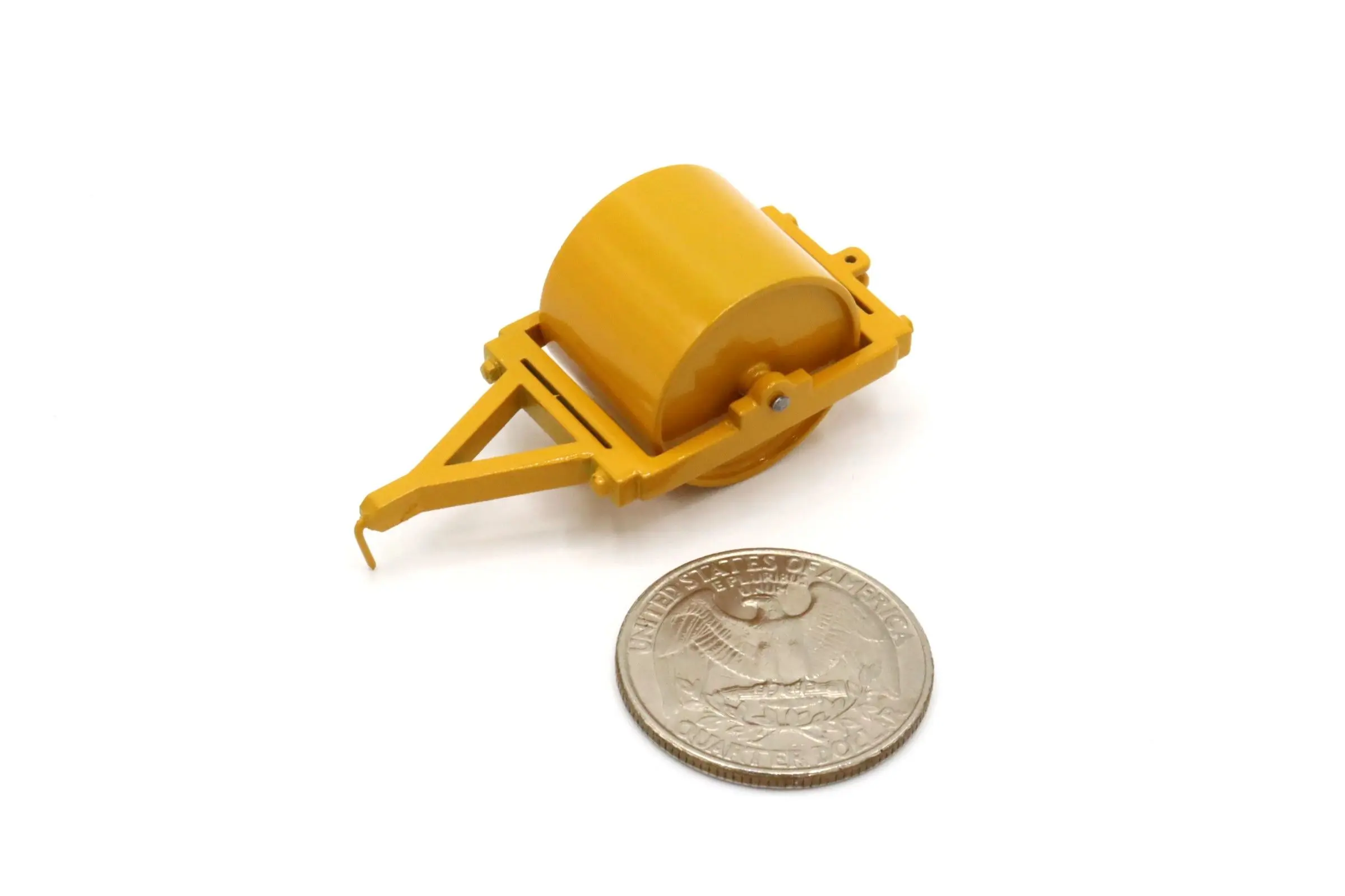 Miniature yellow cement mixer next to a coin for scale.
