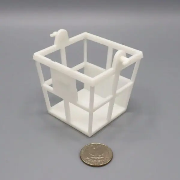 Small white plastic cube with hooks next to a coin for scale.