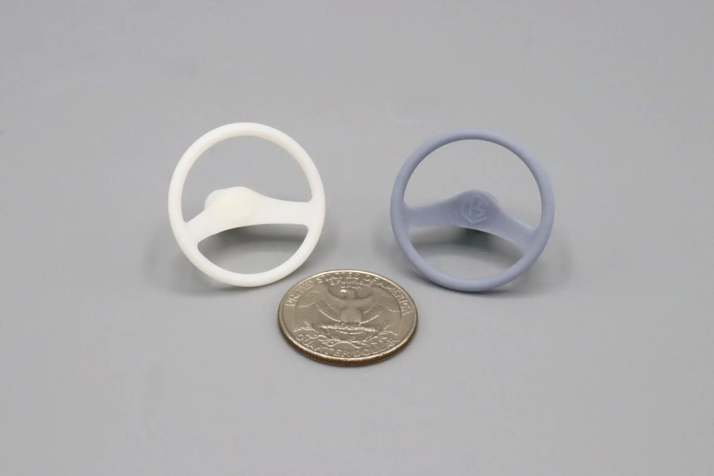 Two small circular plastic objects next to a coin for size reference.