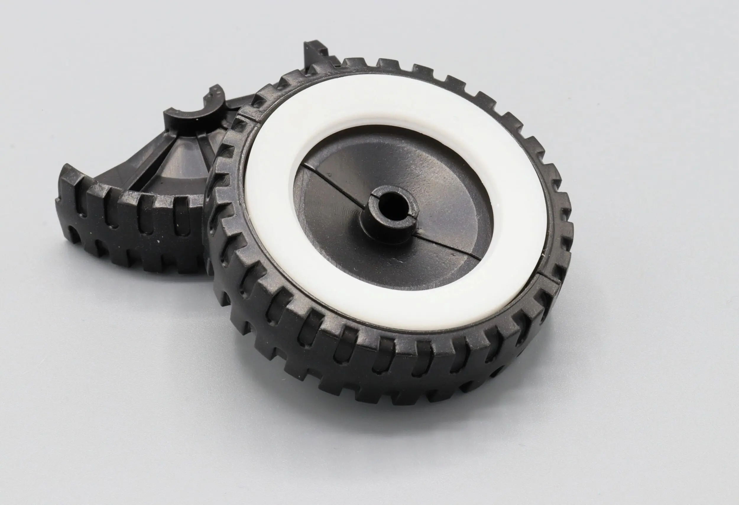 Two black rubber tires with white rims on a white background.