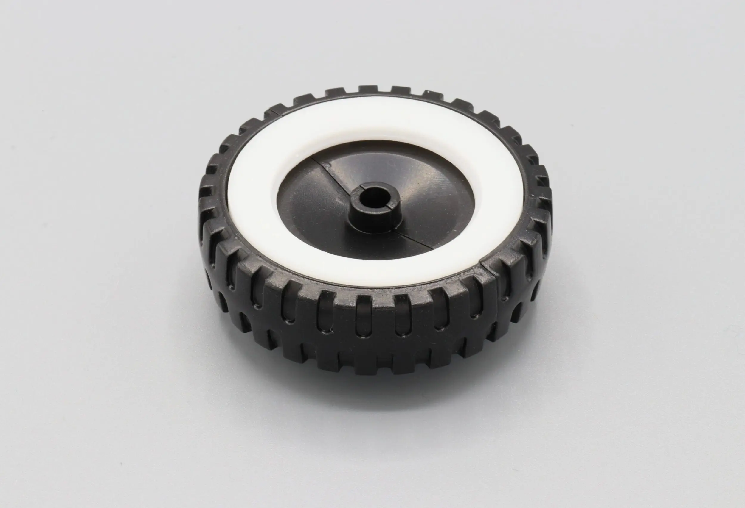 Black and white rubber tire with a plastic hub.