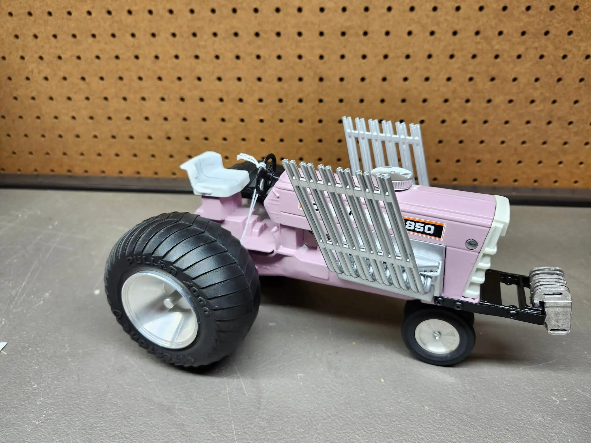 Custom pink tractor model with oversized rear tires and detailed exhaust pipes.