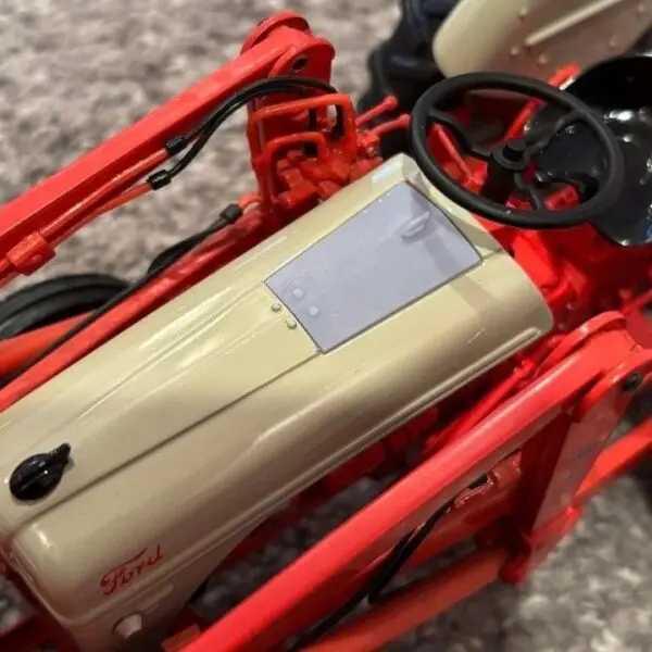 Close-up of a red and cream model motorcycle part.