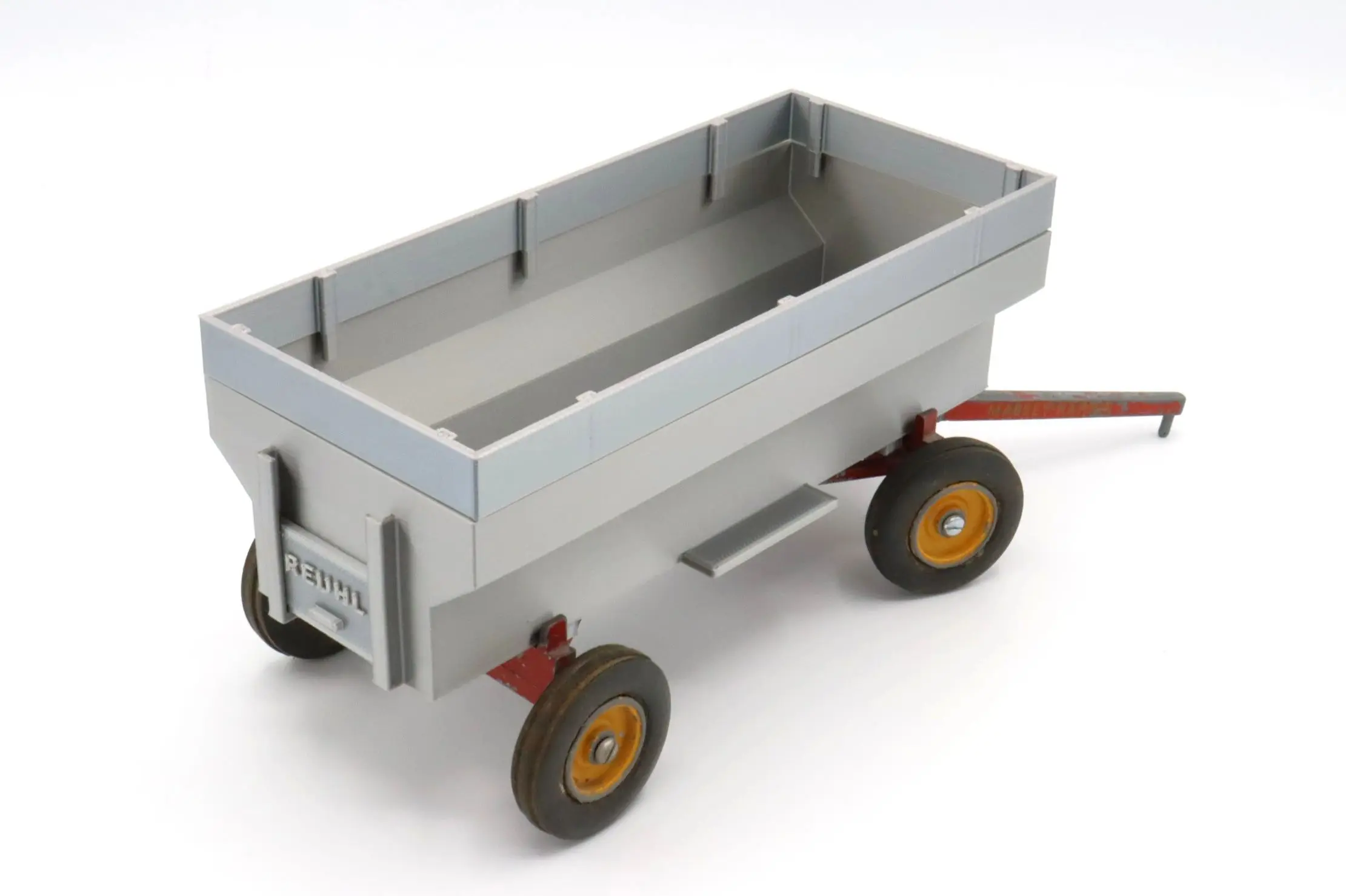 A small gray toy wagon with yellow wheels.