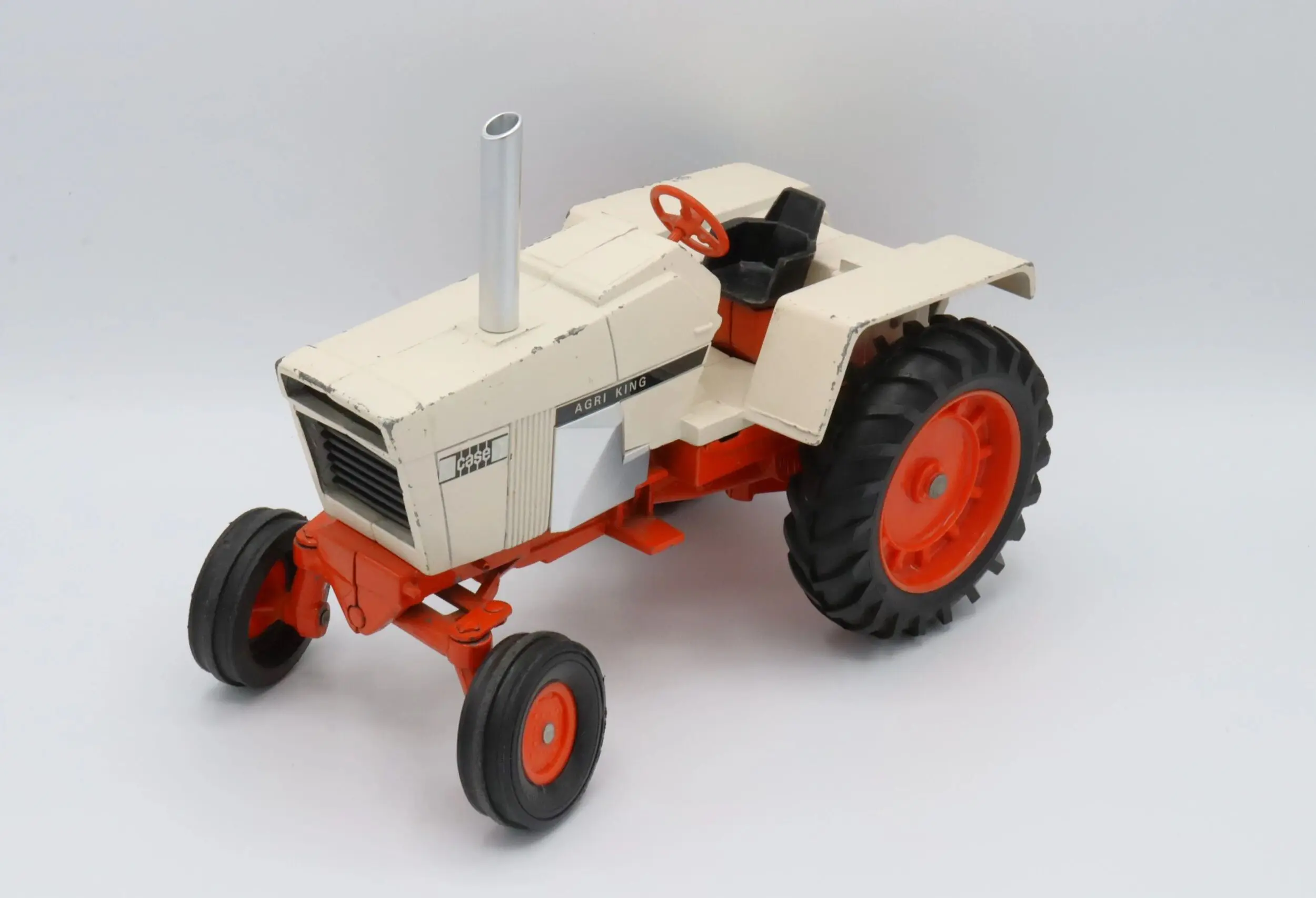 A vintage white and orange tractor with large rear wheels.