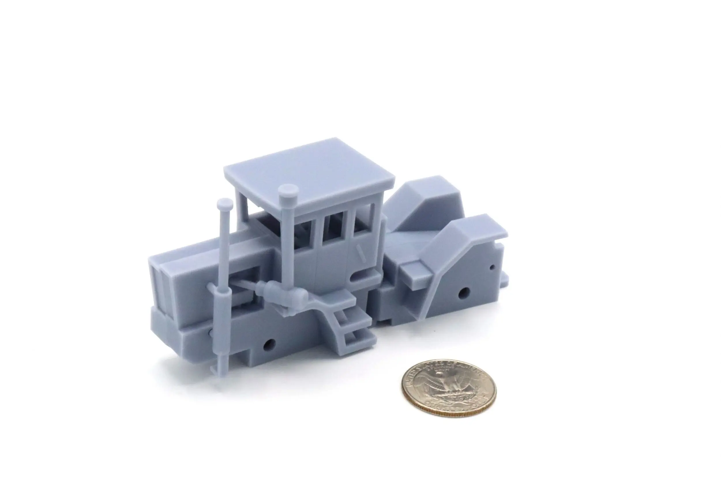 A small 3D printed gray train model next to a coin for scale.