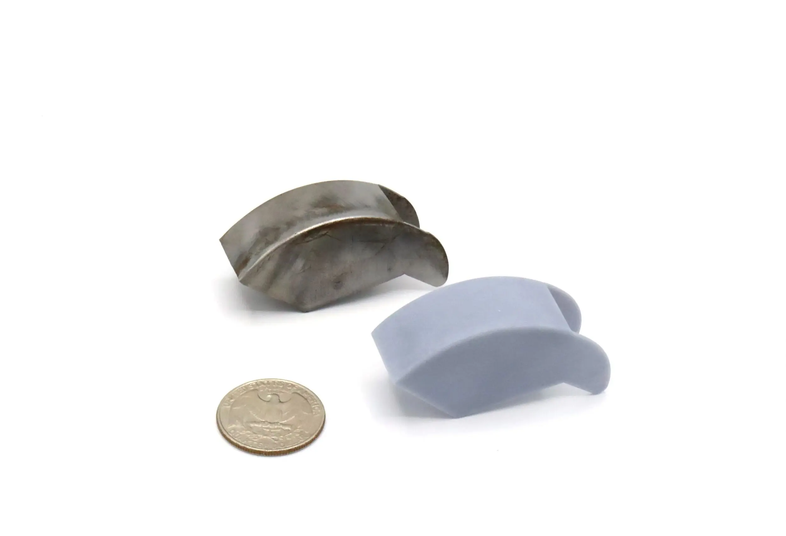 Two small curved magnets beside a coin for scale.