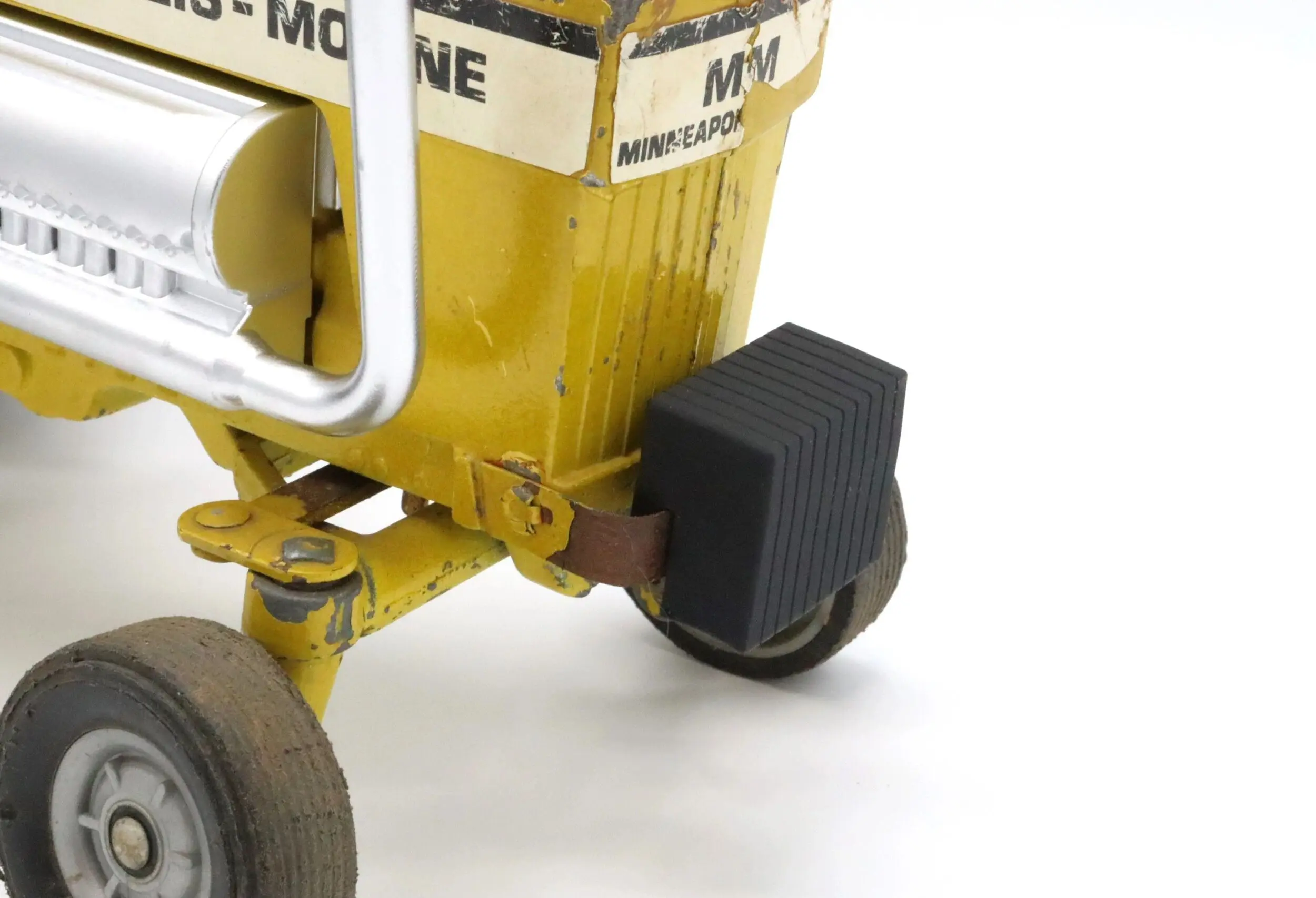Close-up of a black caster wheel on a yellow MyTOne industrial machine.