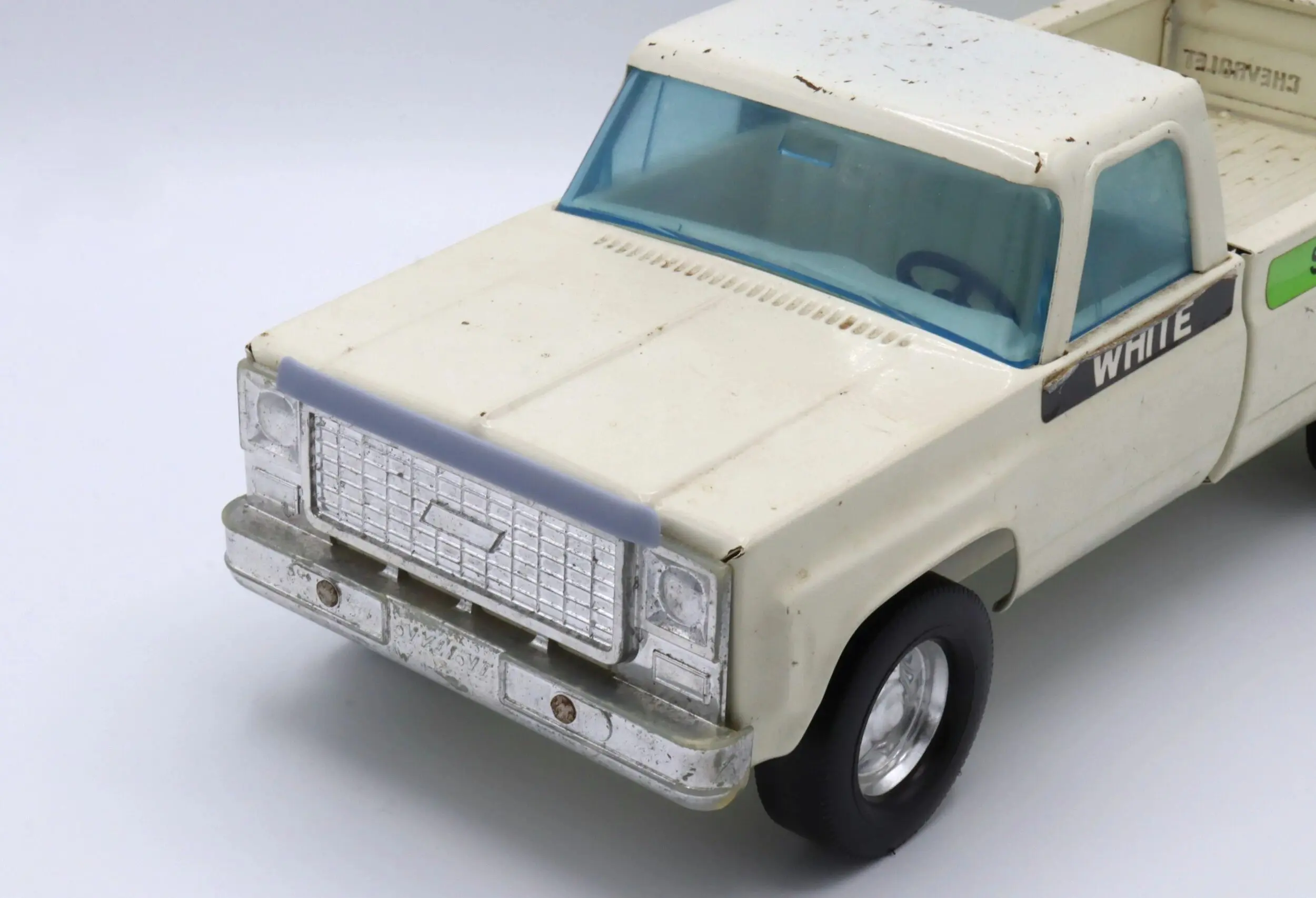 A white toy car with a blue windshield and black wheels.