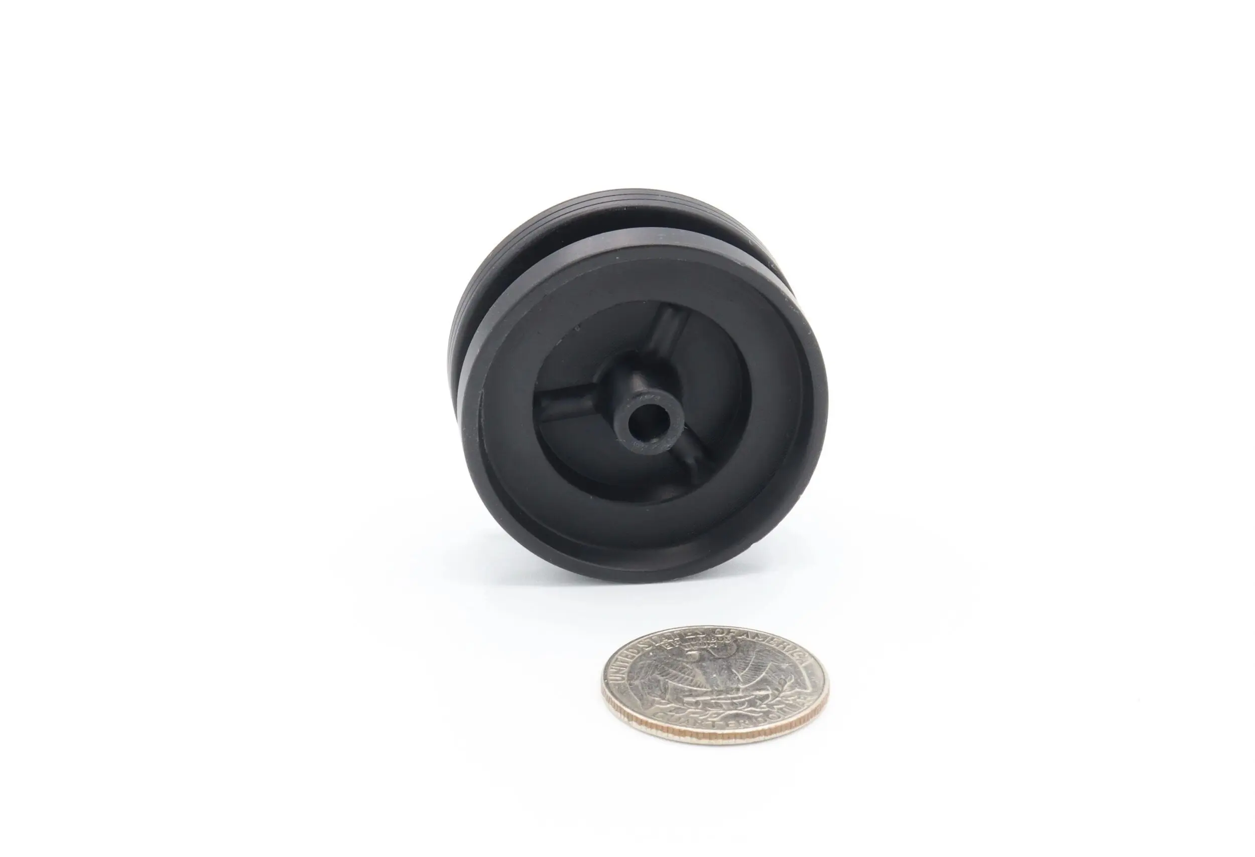 Black yo-yo with a coin for size comparison on a white background.