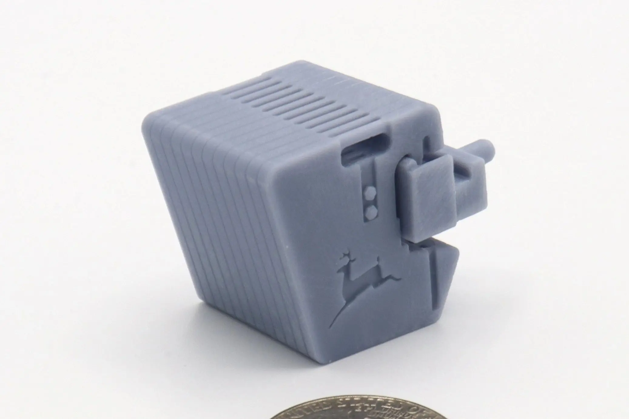 A small gray plastic cube with a clip and ventilation slots.