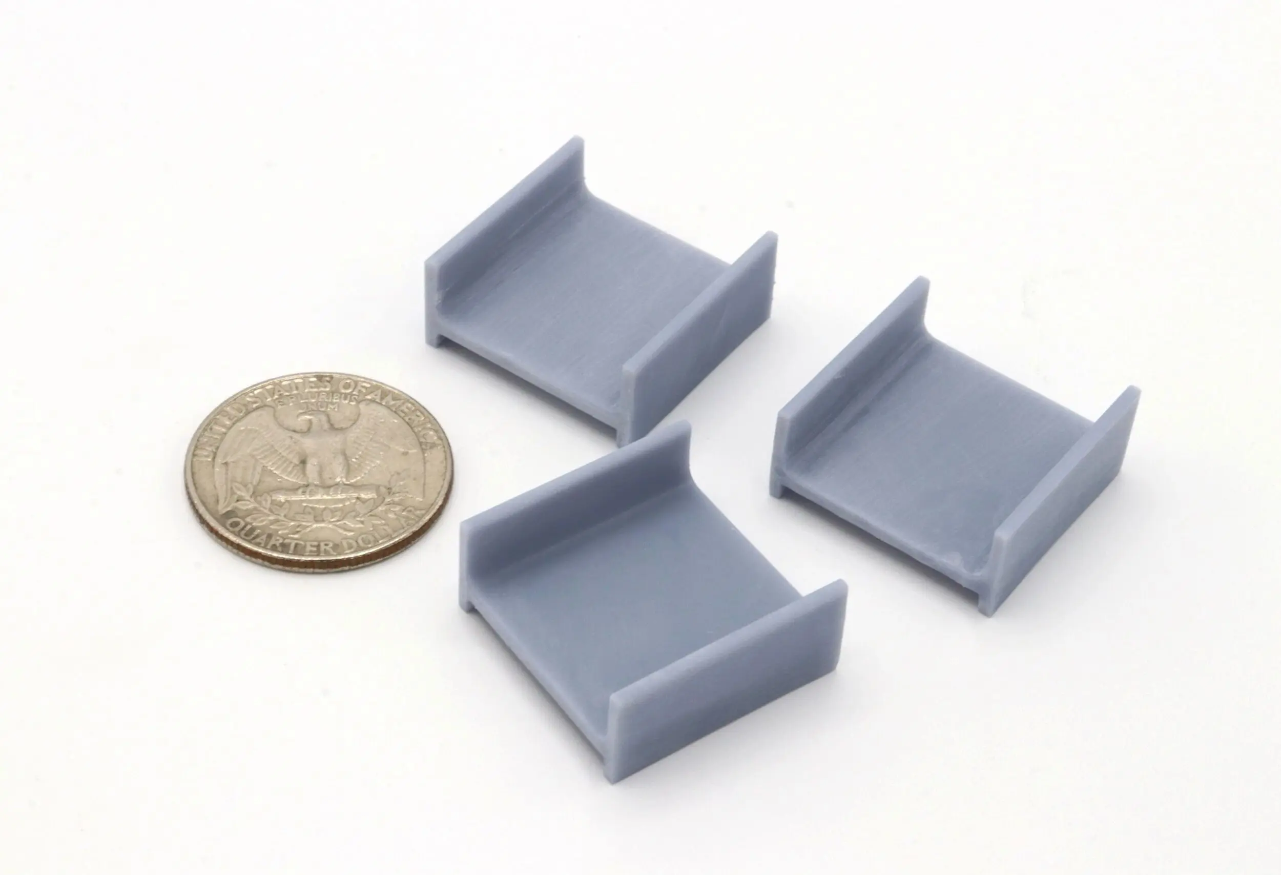 Small gray plastic corner pieces next to a coin for scale.