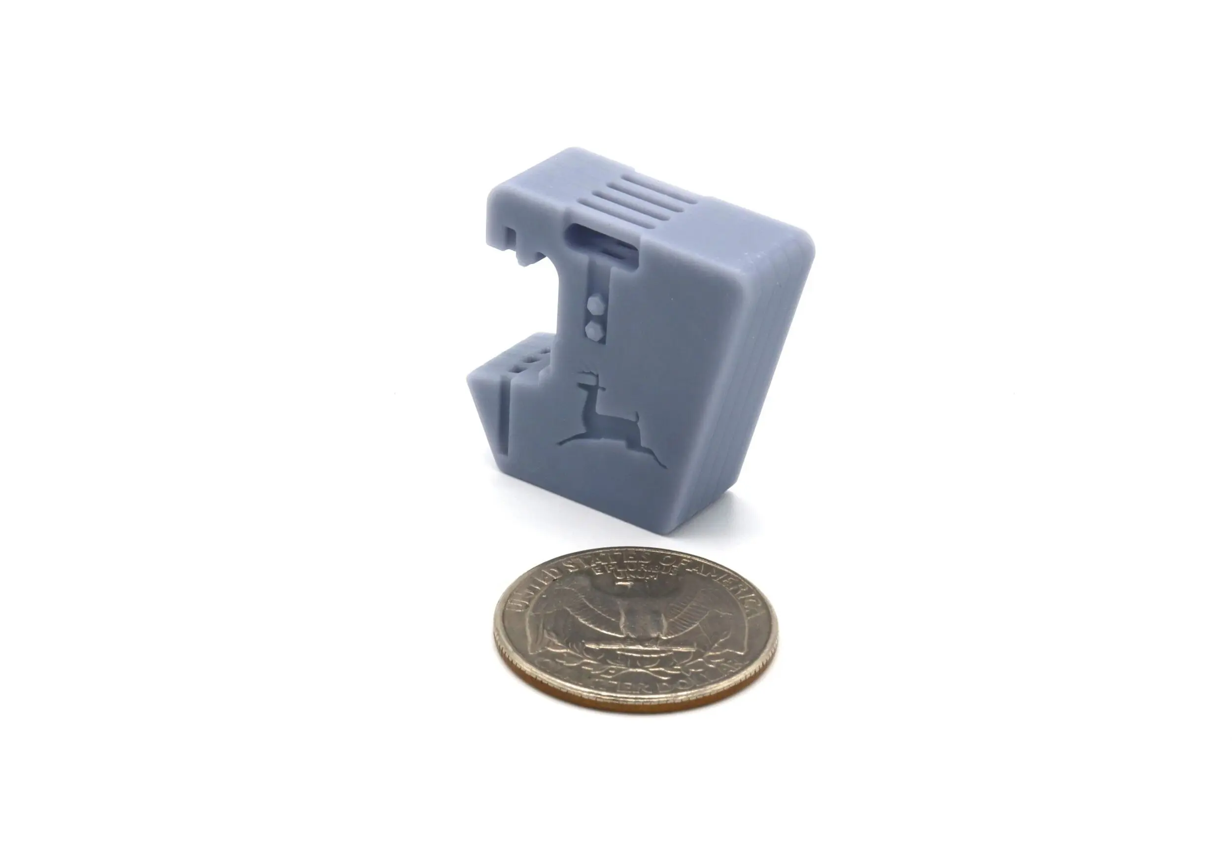 Small gray plastic device next to a coin for size comparison.