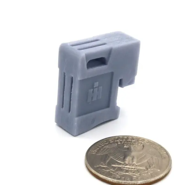 Compact gray electronic device next to a coin for size comparison.