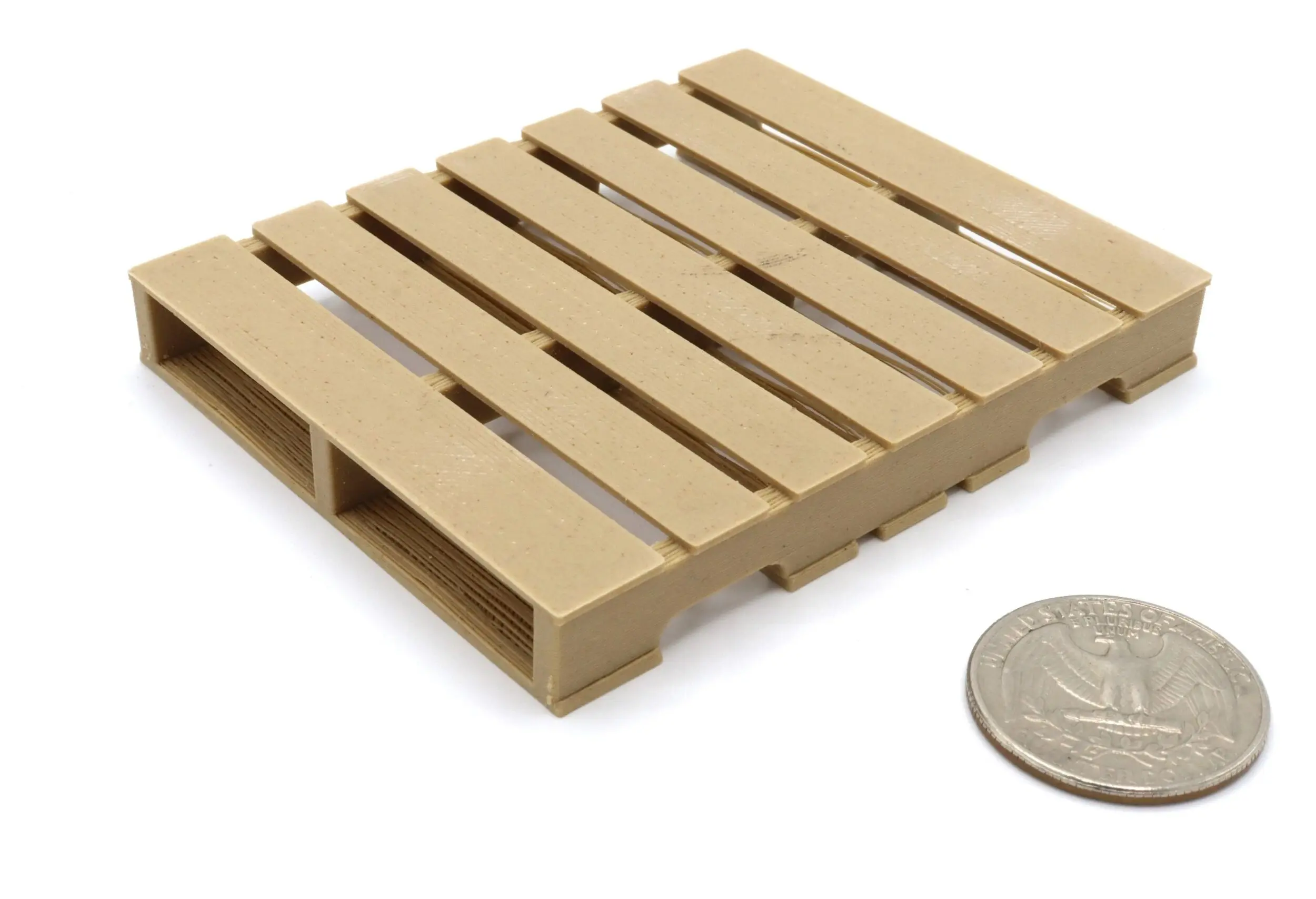 A miniature wooden pallet next to a coin for scale.
