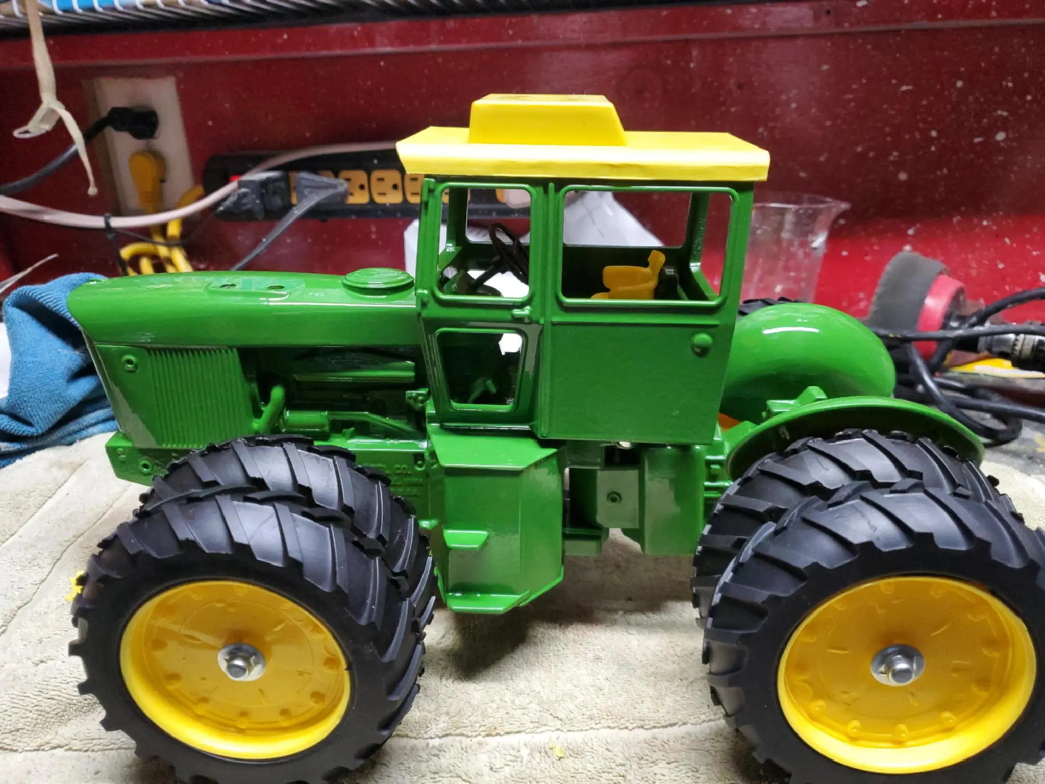 A detailed model of a green and yellow tractor with large tires.
