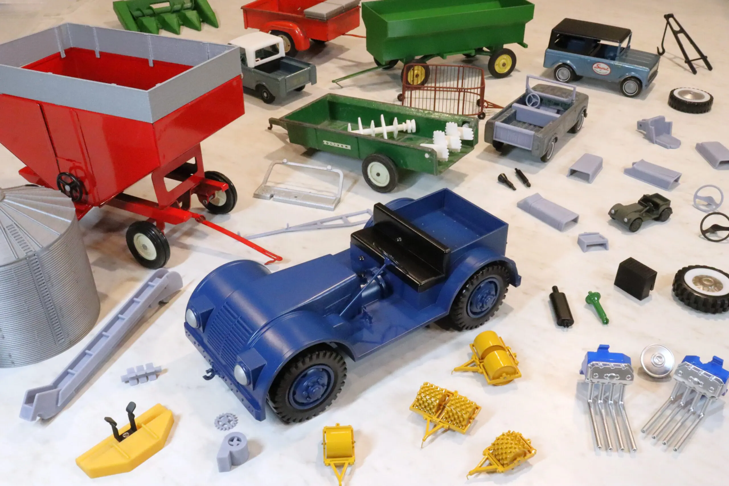 A blue vintage toy car surrounded by various toy parts and accessories.