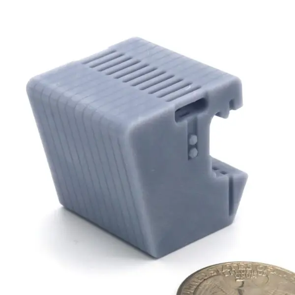 Gray plastic object beside a coin.