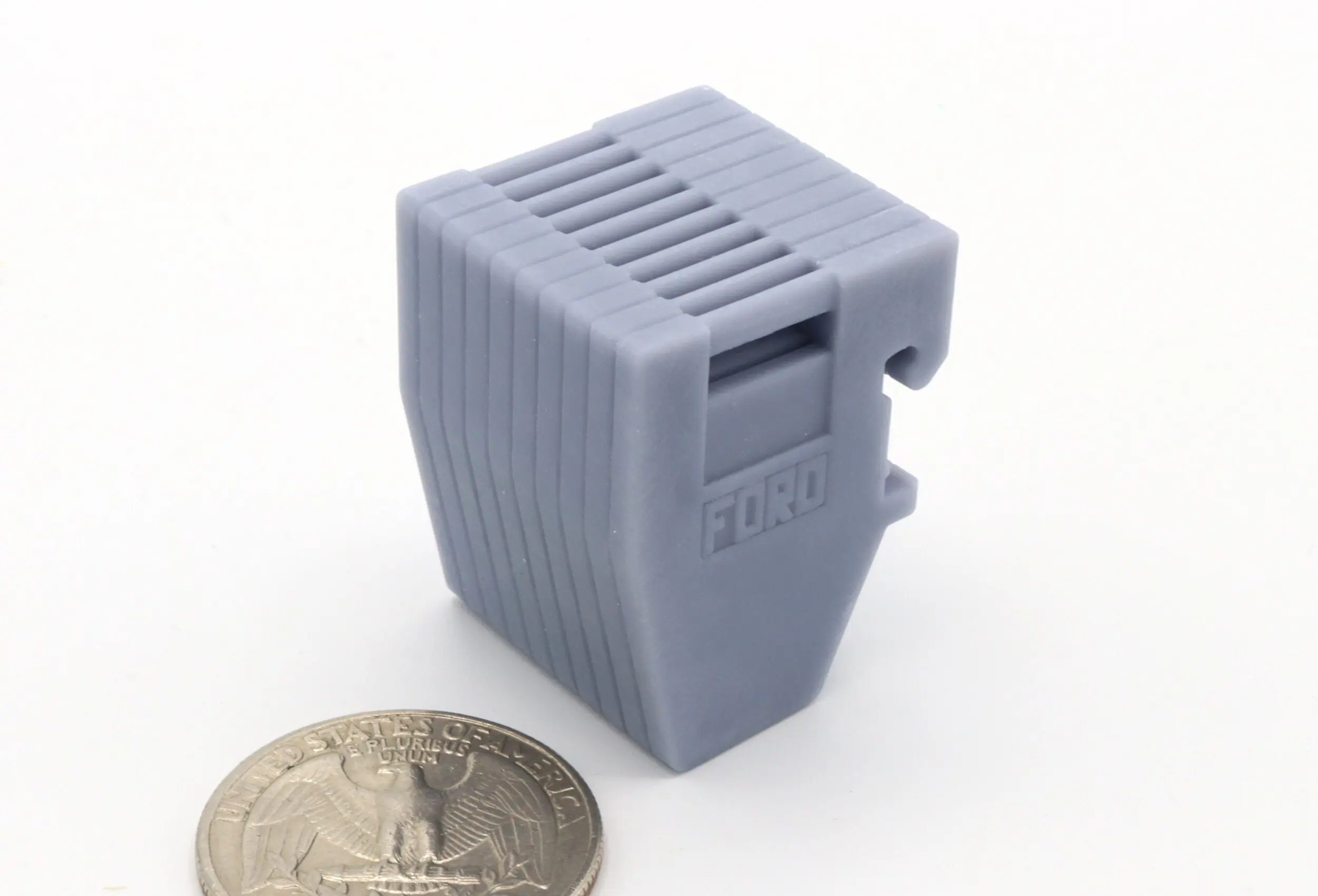 Gray plastic object beside a coin.