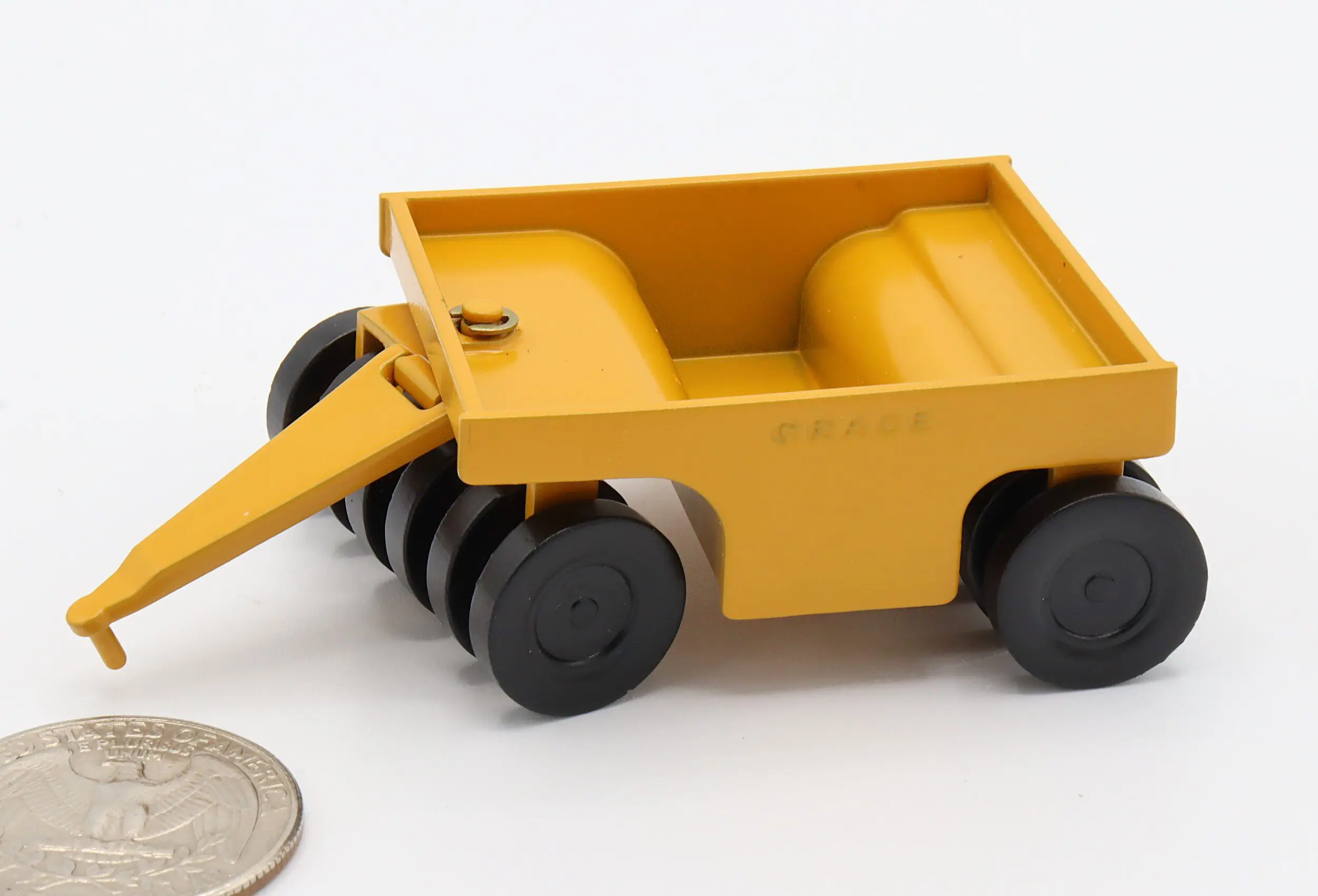 Yellow toy trailer with black wheels.