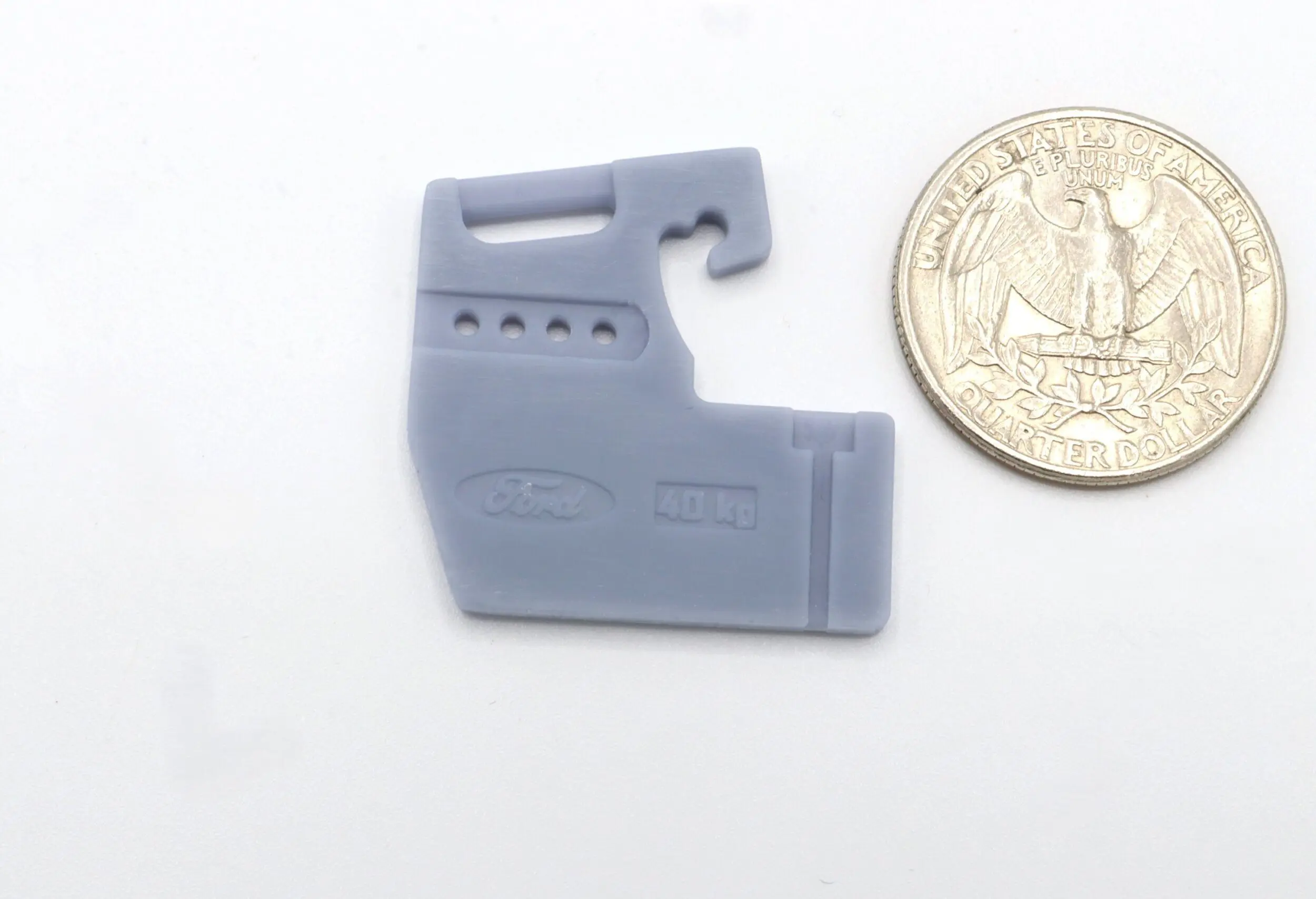 Gray tool next to a US quarter.