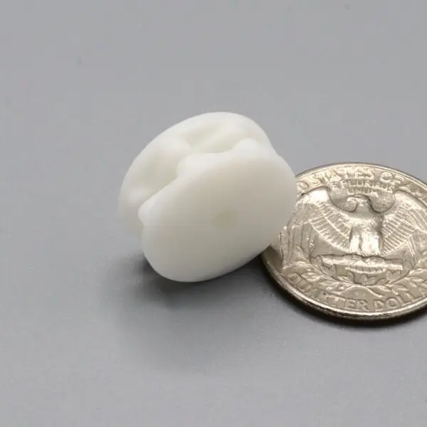 White object beside a quarter on table.