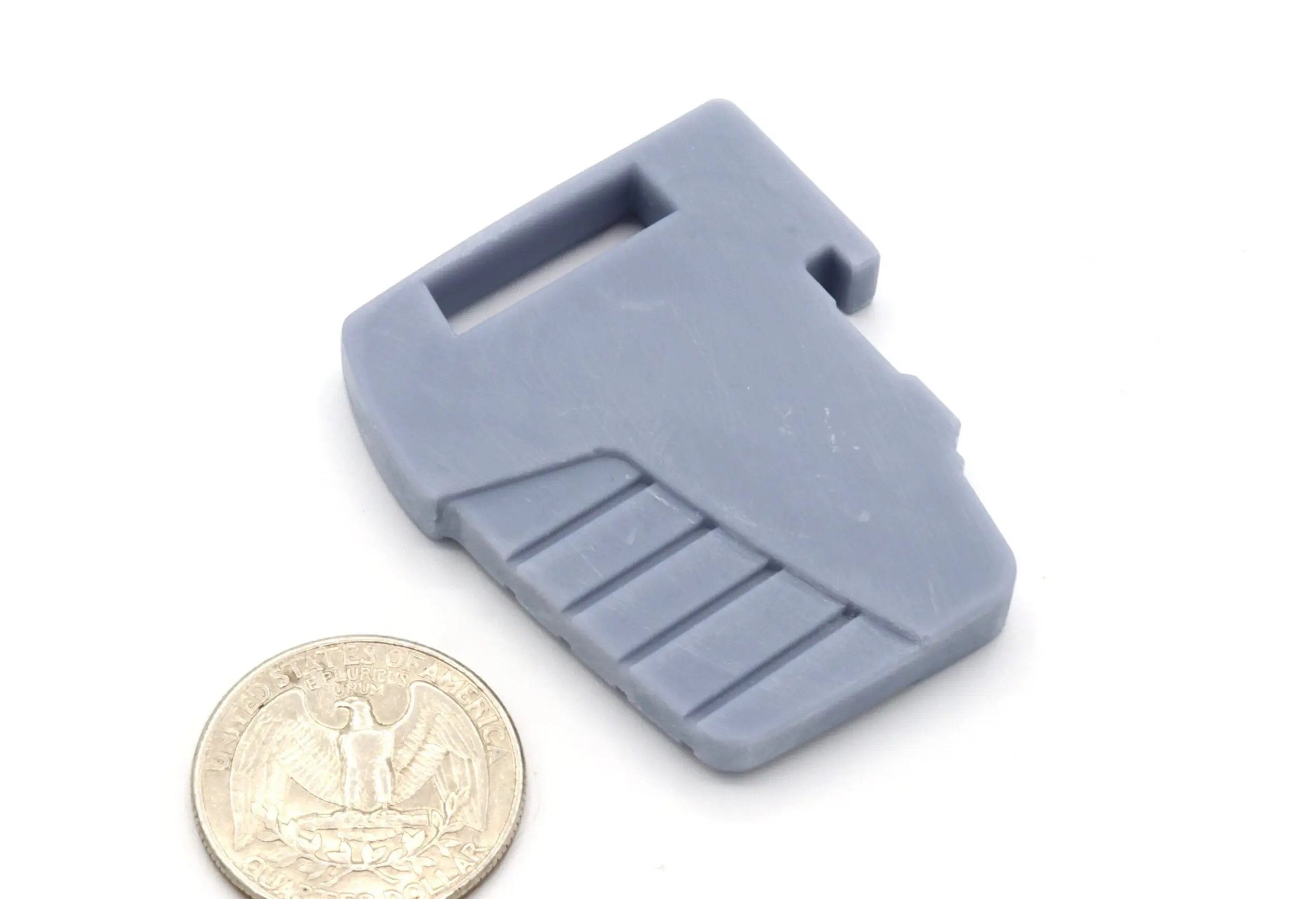 Gray plastic piece beside a coin.