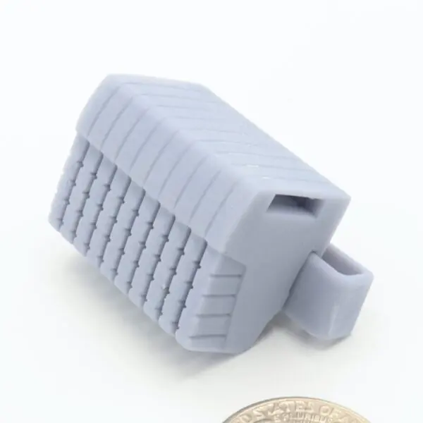 Gray 3D-printed object next to coin.