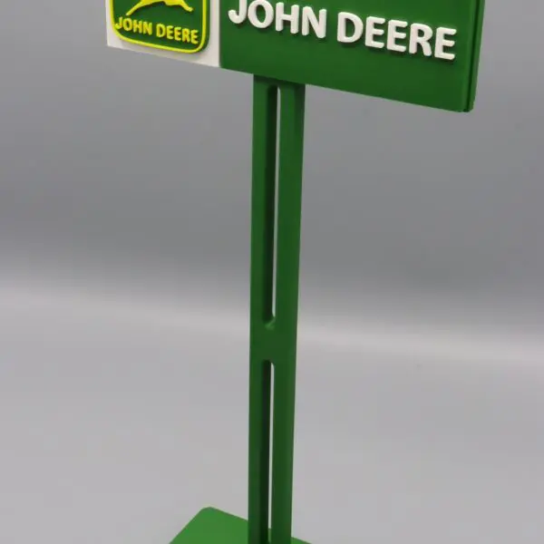 Green John Deere sign on gray background.