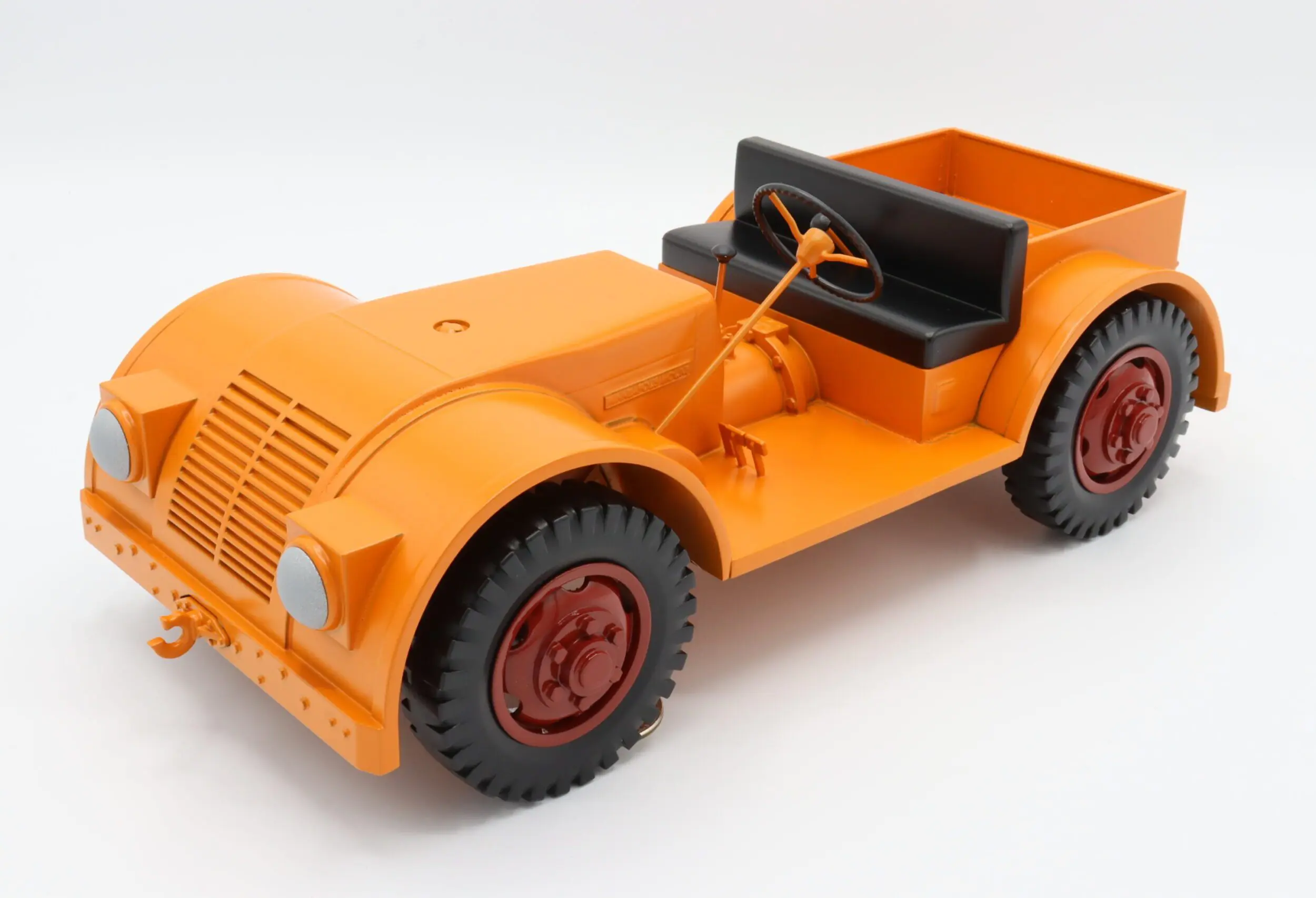 Orange vintage toy car with black seat.