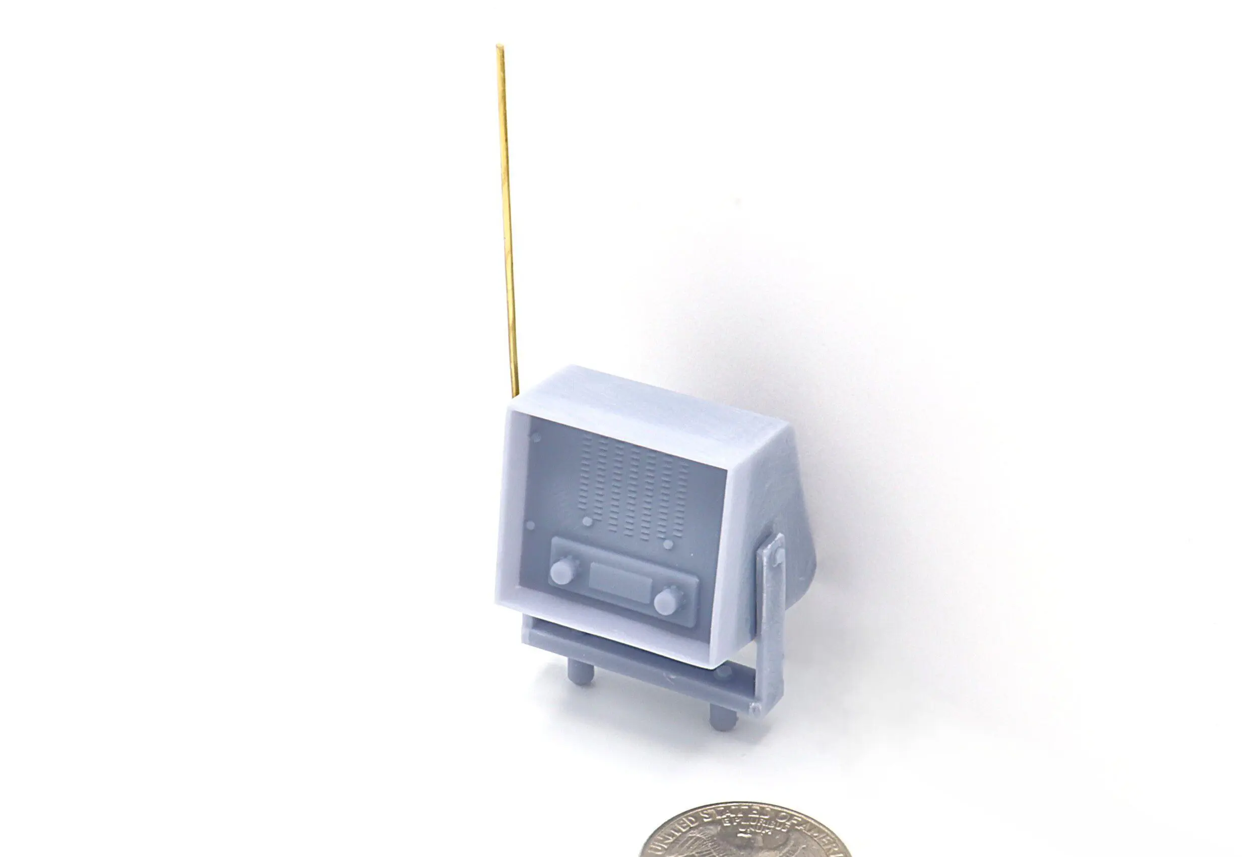 Miniature retro TV with antenna and coin.