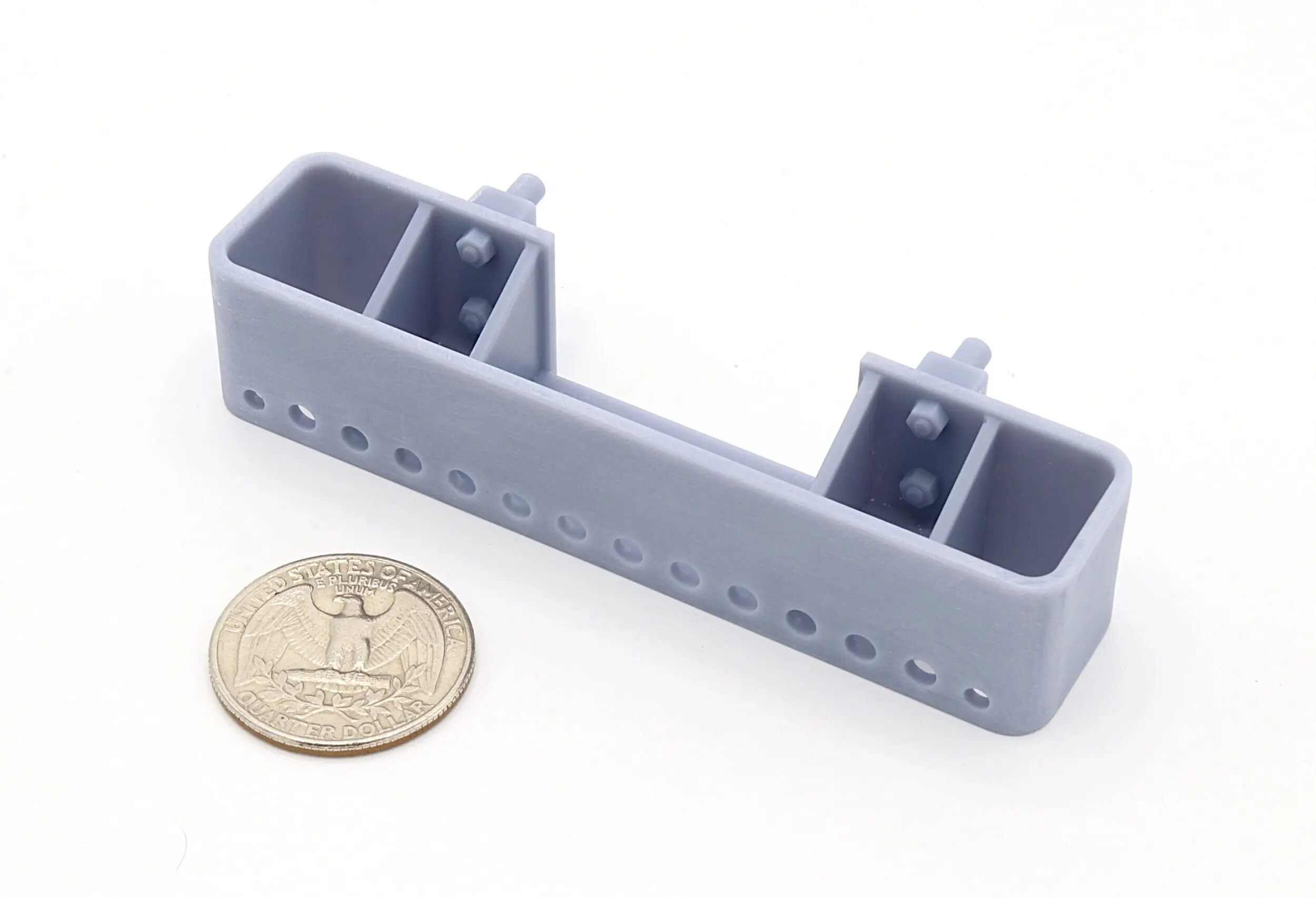 Gray plastic bracket next to a coin.