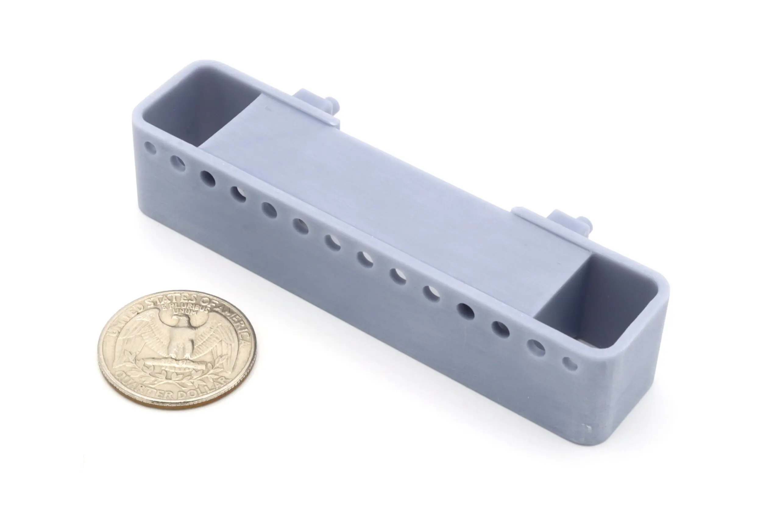Gray rectangular object next to a coin.