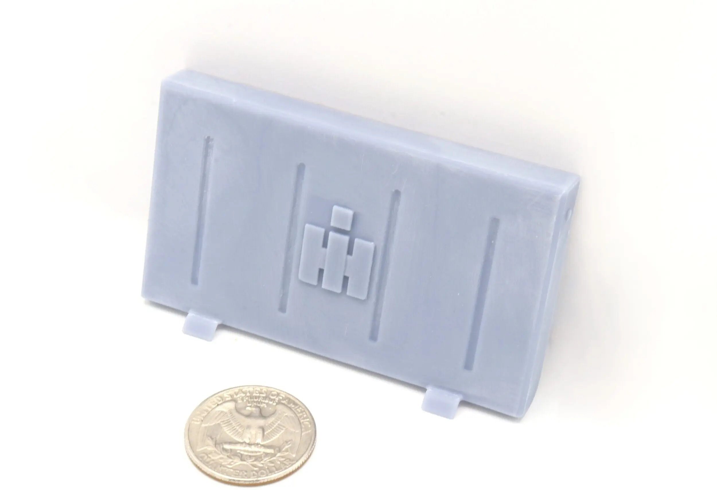 Gray molded part beside a quarter coin.